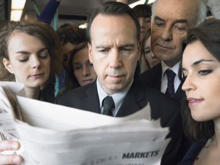 Group of commuters reading newspaper in the train