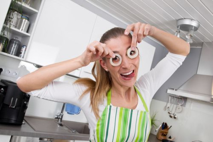 Young woman posing with onion rings in the kitchen