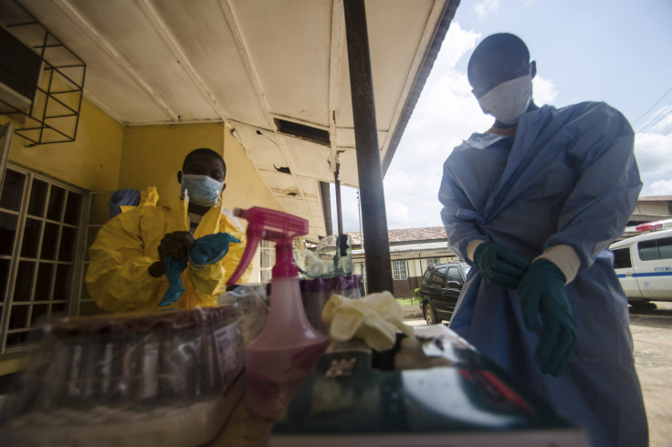 Medical staff puts protective gear in Kenema government hospital before taking a sample from a suspected Ebola patient