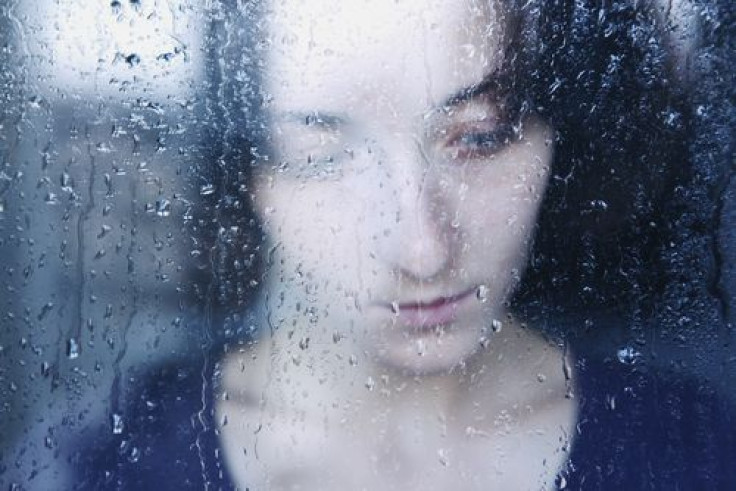 Sad woman in a rainy window