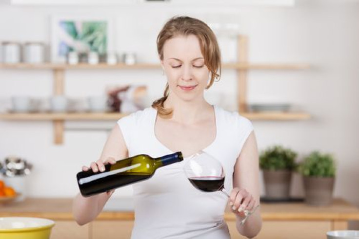Woman pouring herself a glass of wine in the kitchen
