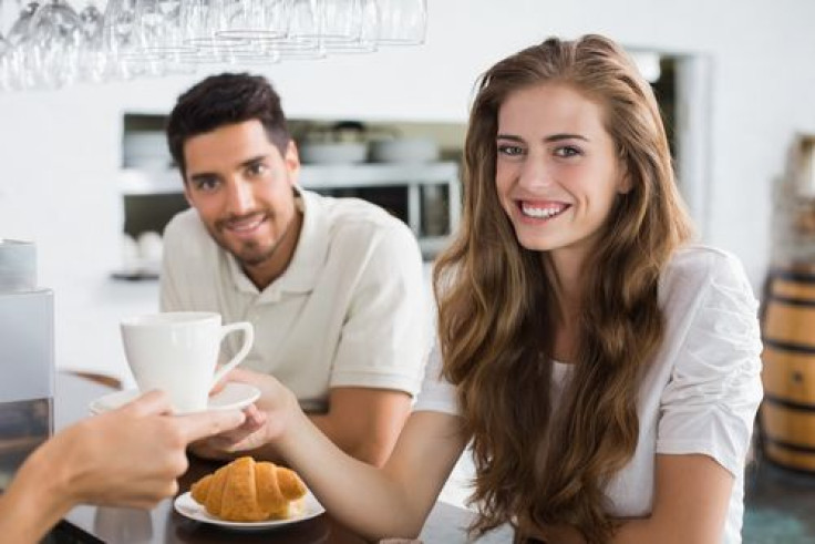 Woman taking coffee from barista 