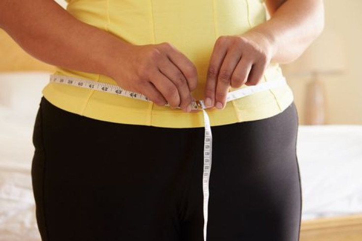 Overweight woman measuring her waist