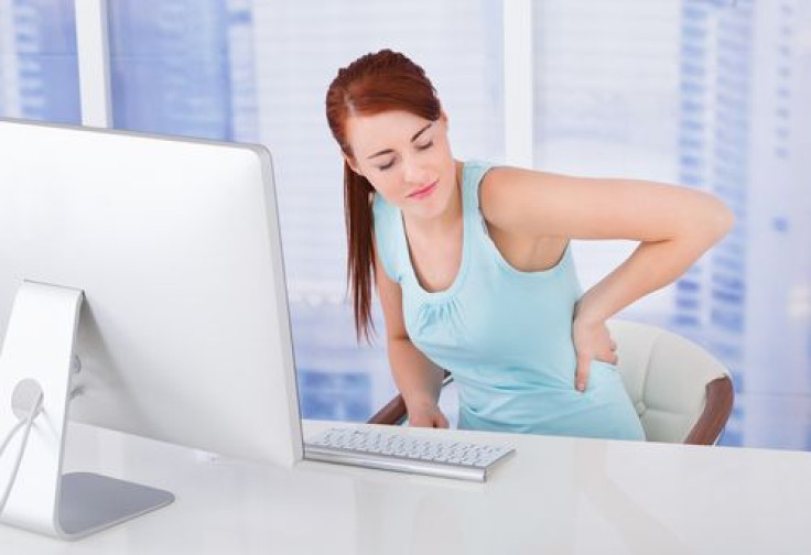Businesswoman with back pain in office