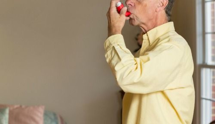 An older man using an inhaler