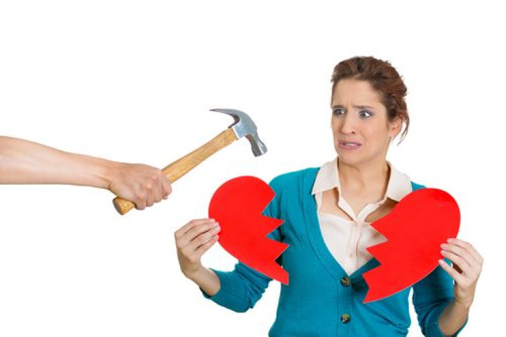 Woman holding broken heart from hammer