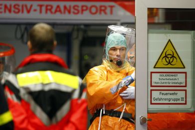 Medical staff members wearing sealed protective suits work during the arrival of an Ebola patient at the Universitaetsklinikum Frankfurt (University Hospital Frankfurt) in Frankfurt, October 3, 2014.
