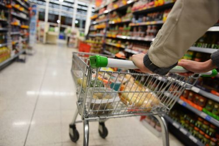 Supermarket aisle view of shopping cart and shelves