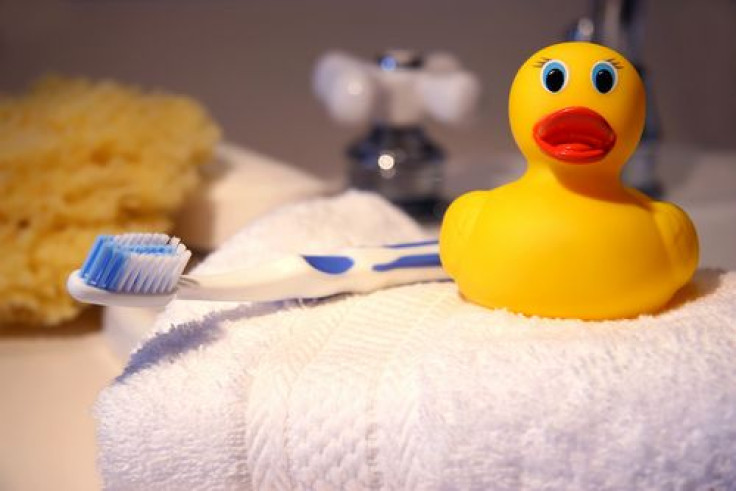 ubber duck, toothbrush and sponge on bathroom counter