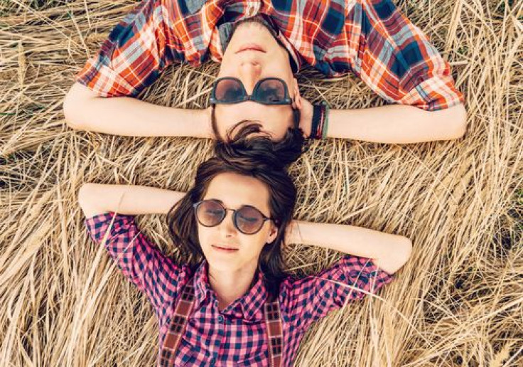 Hipster style couple is lying on meadow
