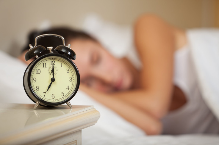 Sleeping woman and alarm clock in bedroom at home