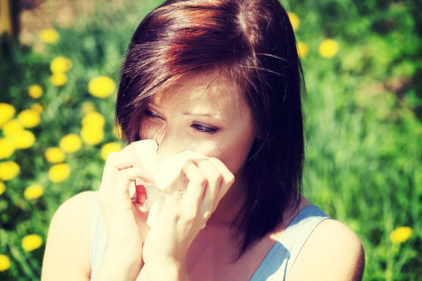 A woman sneezing due to an allergy.