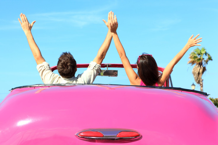 Happy free couple in car driving in pink vintage retro car 