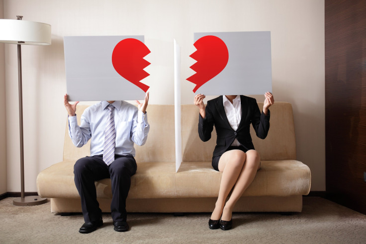 Sad young couple holding billboard sign with break love heart