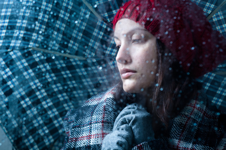 Sad woman with umbrella on a rainy day