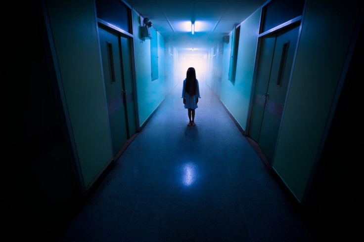 Little girl in empty and dark hallway