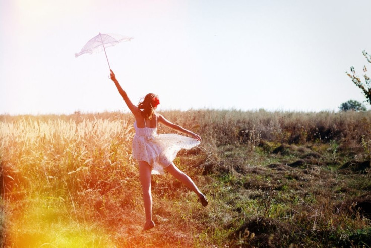 Woman alone in the field with umbrella 