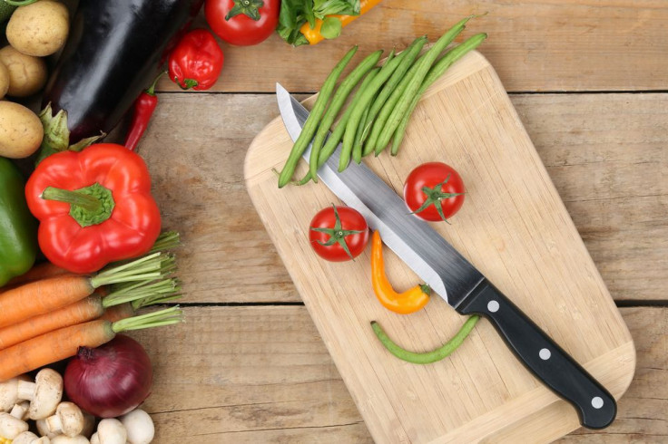 Preparing food smiling vegetables face on cutting board with knife