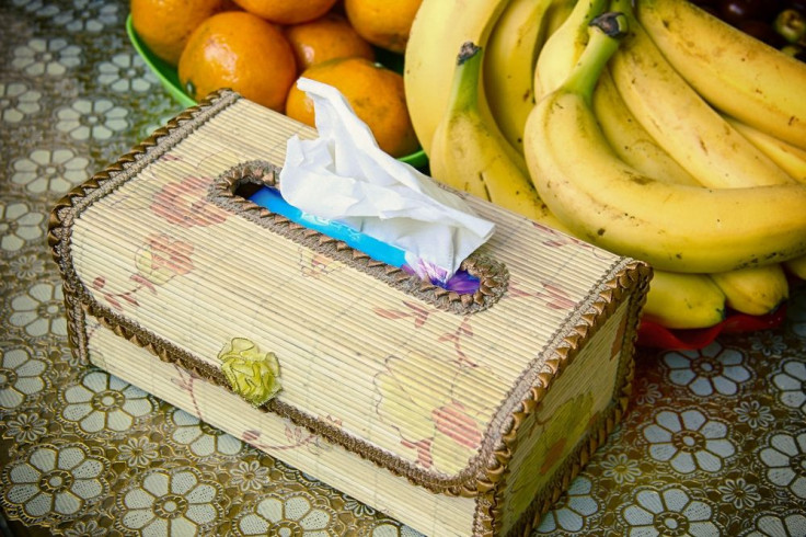 Tissue box next to bananas and oranges