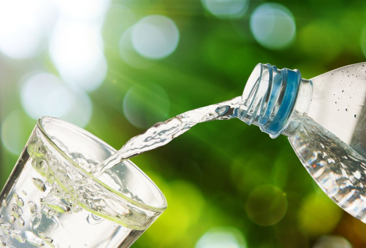 Drinking water poured from bottle into glass