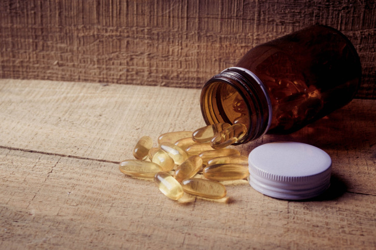 A bottle of pills on a wooden surface.