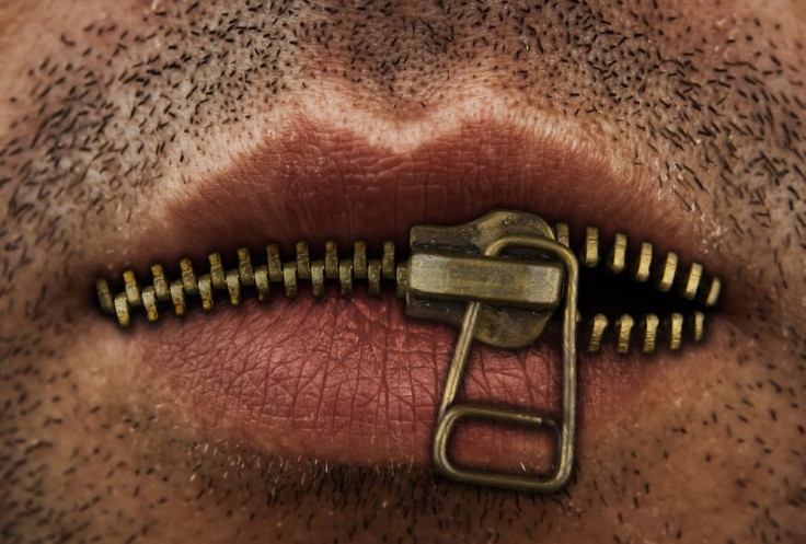 Man's mouth with bronze or gold metal zipper closing lips shut