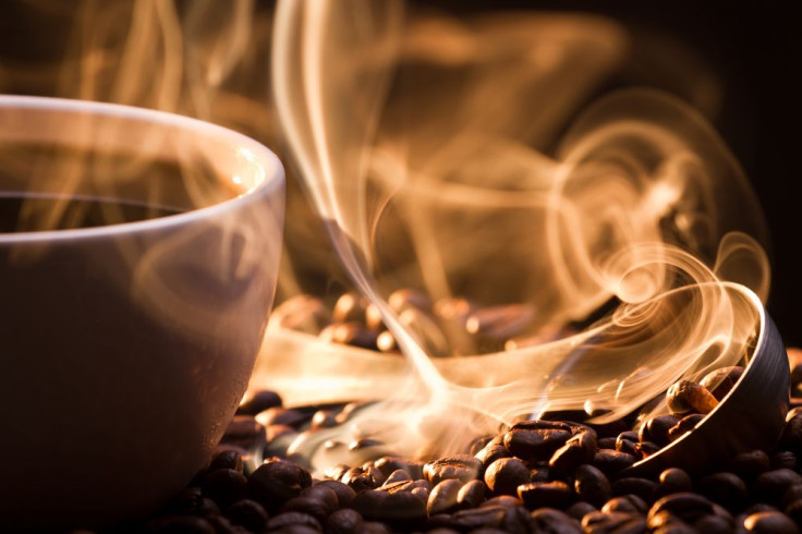 Big aroma of coffee from cup next to coffee beans