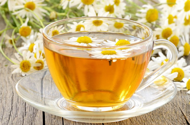 Herbal chamomile tea with chamomile flowers on wooden table