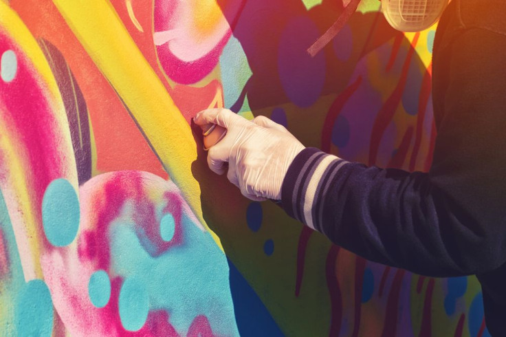 Graffiti artist paint spraying the wall