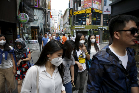 Women wearing masks to prevent contracting Middle East Respiratory Syndrome (MERS) walk at Myeongdong shopping district in central Seoul, South Korea, June 11, 2015.