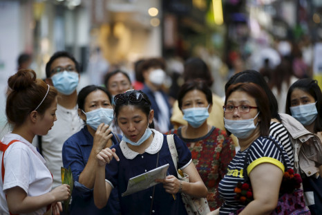 A tourist wearing a mask to prevent contracting Middle East Respiratory Syndrome (MERS) asks a sales assistant for directions as they tour Myeongdong shopping district in central Seoul, South Korea, June 12, 2015.