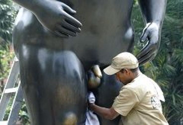 Worker cleans a statue by Fernando Botero