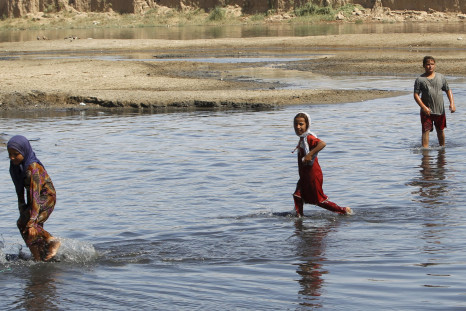 Iraqi children are seen in a swamp in eastern Baghdad's al-Futheliyah district, September 20, 2015.