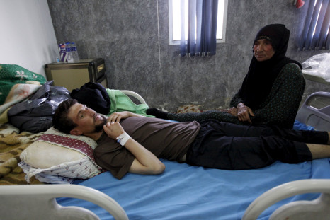 A woman sits near her son suffering from cholera at a hospital in Baghdad, September 21, 2015.