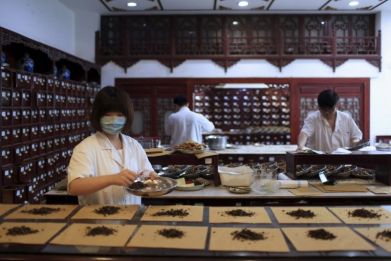 Employees work at a traditional Chinese medicine shop in Shanghai, China, September 16, 2015.