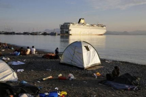 Syrian refugees camp by the port as the passenger ship 