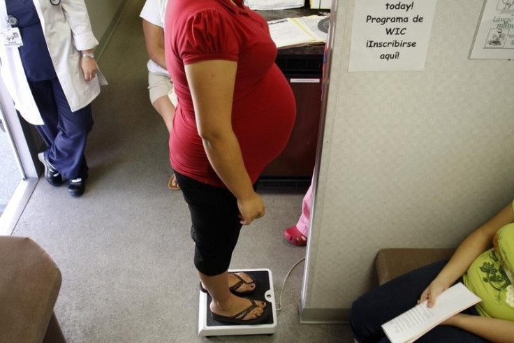 Pregnant woman stands on a scale. 