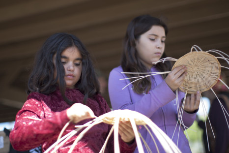 Girls weave baskets at the annual traditional agave roast at the Malki Museum on the Morongo Indian Reservation near Banning, California, April 11, 2015.