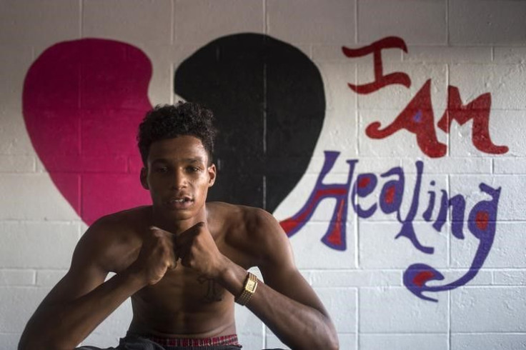 Boy poses in front of a mural. 