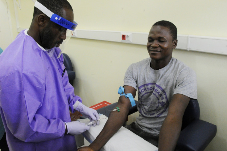 A health specialist takes a blood sample from an Ebola survivor.