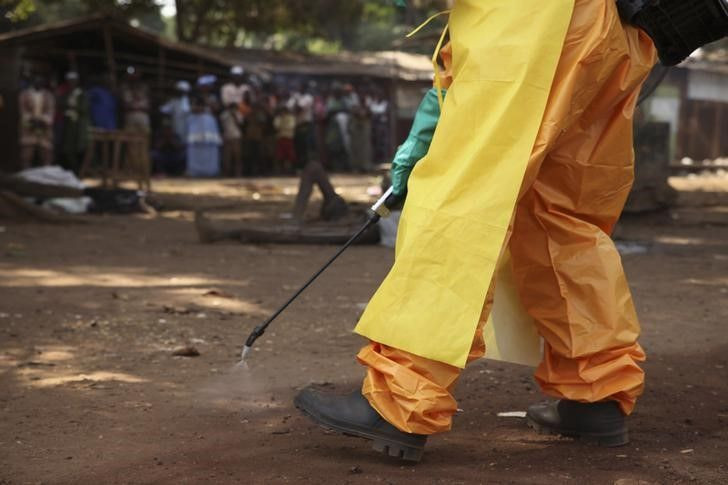 A healthcare workers disinfects the surrounding area.