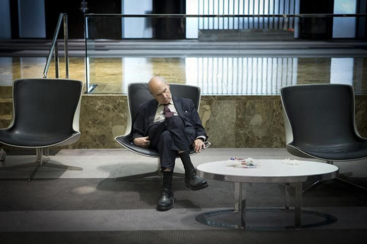 A businessman naps while sitting in the lobby of a hotel.