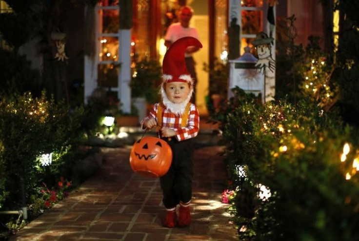 A young boy goes trick-or-treating for Halloween. 