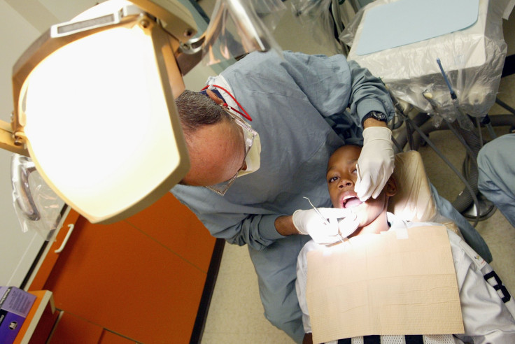 A dentist performs a dental examination on a young boy.