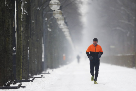 A jogger runs along a snow covered path through Tiergarten after heavy snowfall in Berlin, Germany, January 6, 2016.