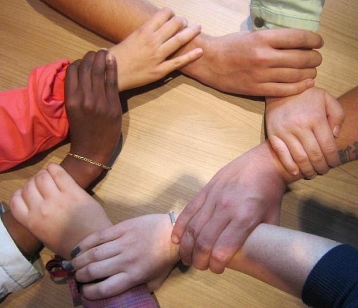 Hands of different races holding wrists