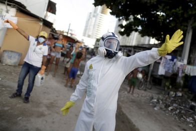 Municipal workers gesture before spraying insecticide at the neighborhood of Imbiribeira in Recife, Brazil, January 26, 2016.
