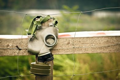 A gas mask is pictured on a fence.