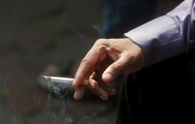 A man smokes a cigarette along a road in Mumbai, India.