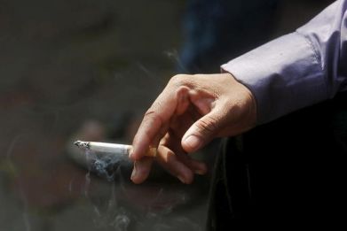 A man smokes a cigarette along a road in Mumbai, India.